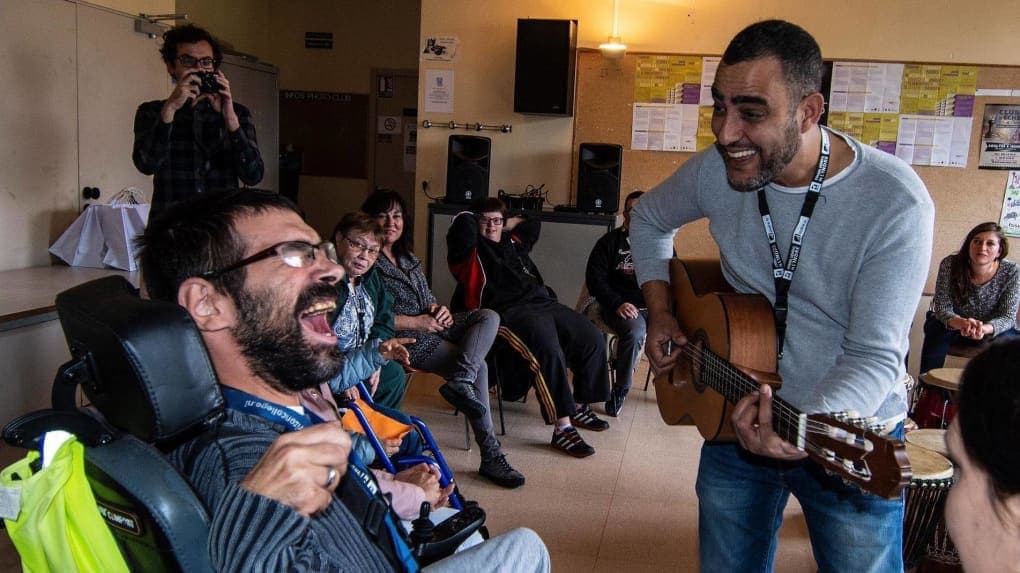 Lahouari Bouregaya, guitare en main, anime un atelier musical avec des personnes accompagnées